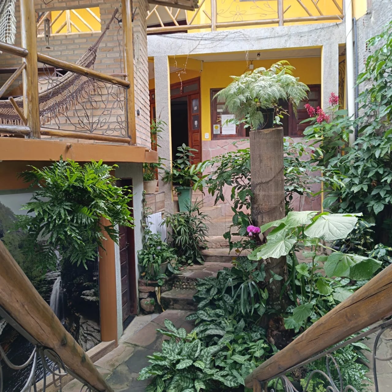 Varanda da pousada com rede e vista para a cidade