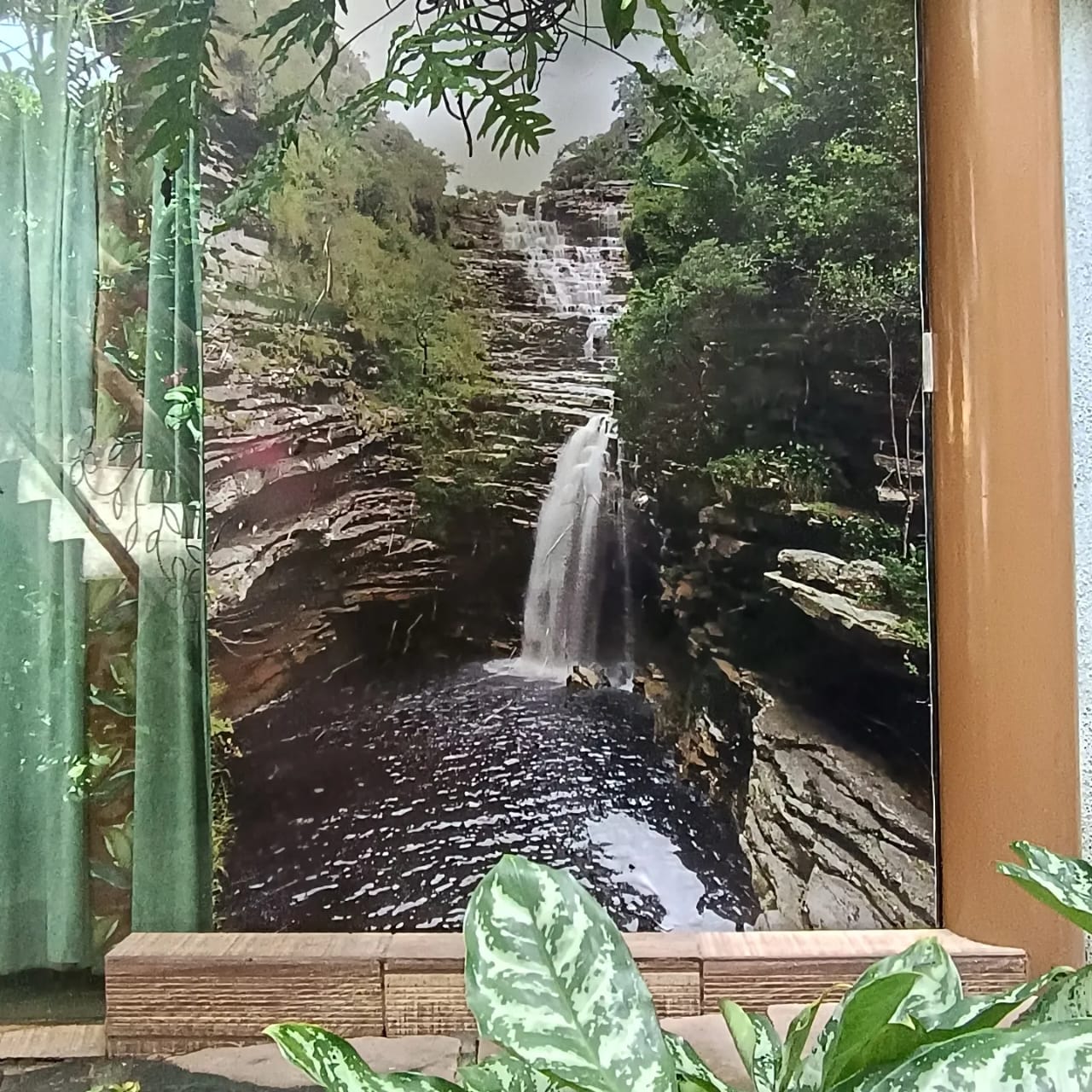 Painel com foto de cachoeira da Chapada Diamantina no jardim da pousada