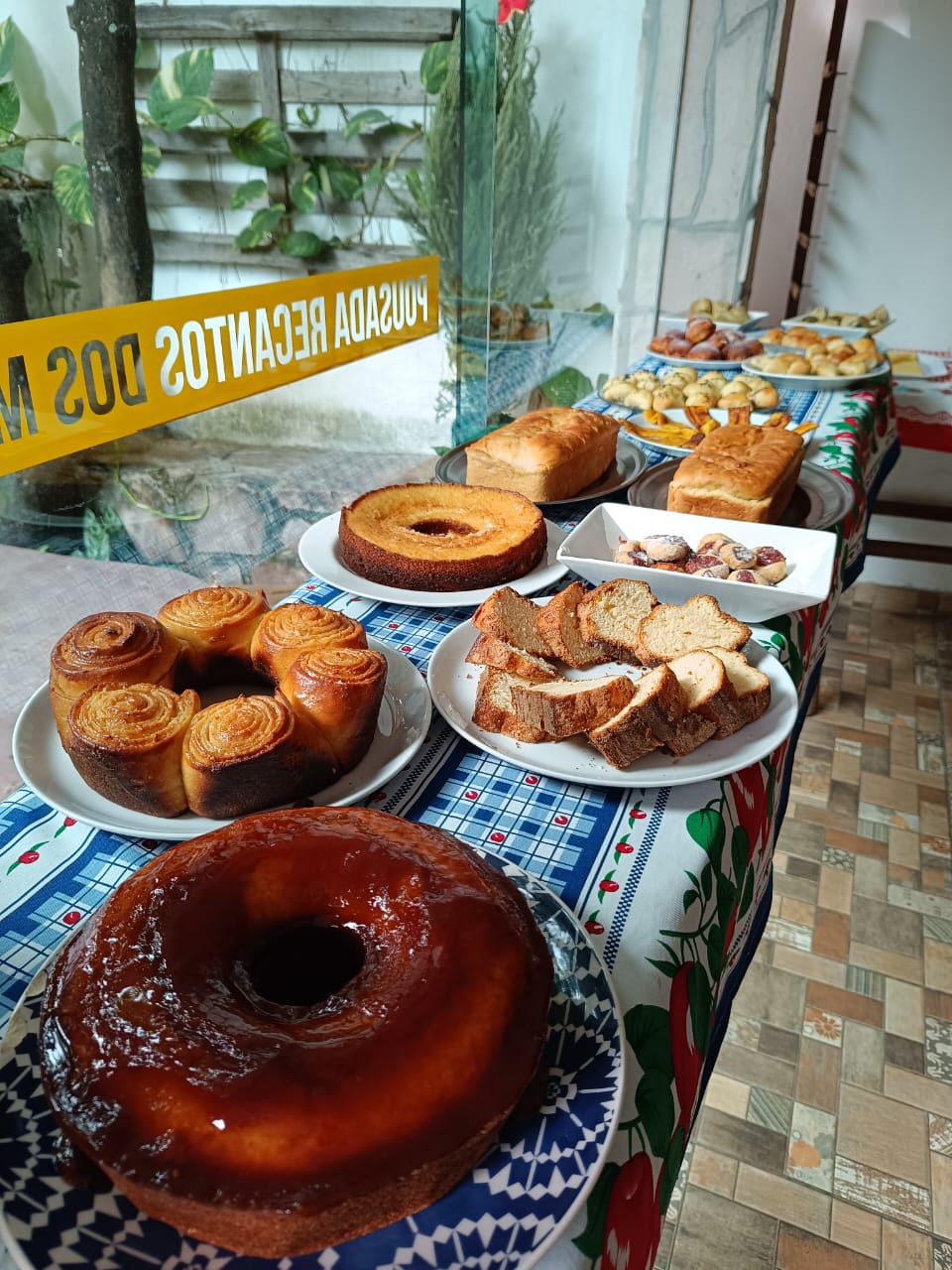 Mesa do café da manhã com bolos, pães, biscoitos e frutas